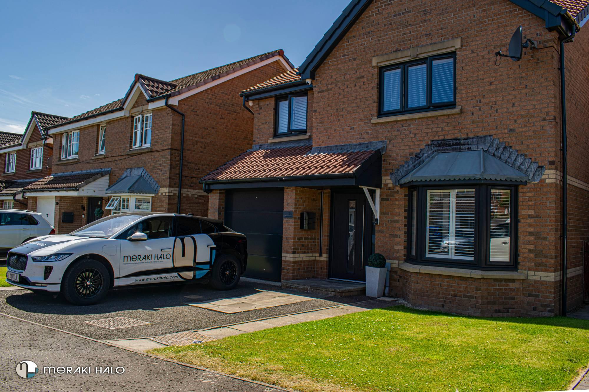 Brick house with new windows and the Meraki Halo car