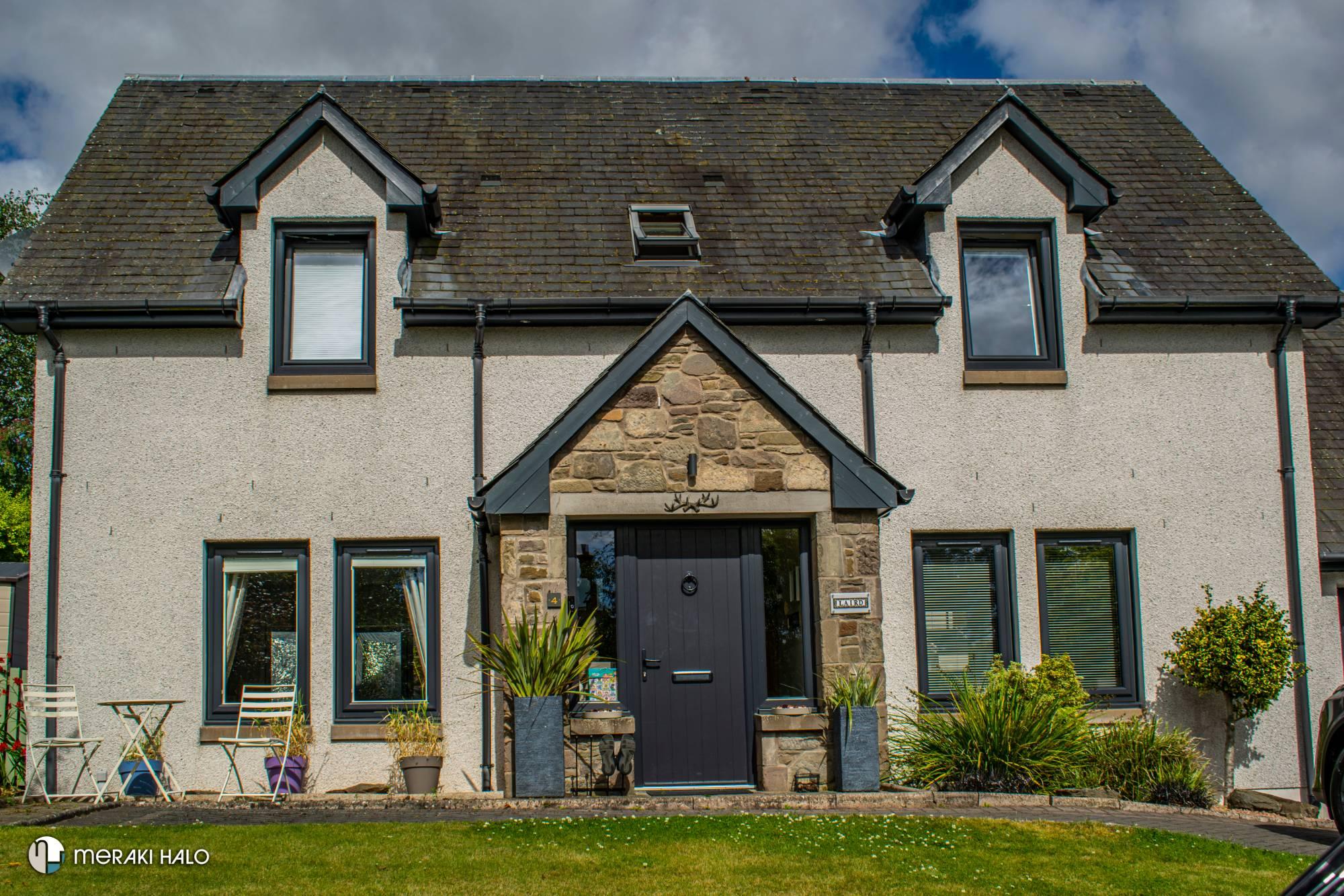Stone cottage with dark grey windows and front door